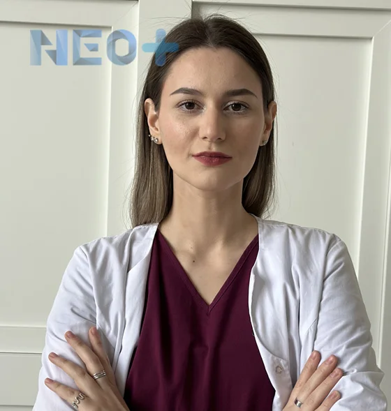 женщина врач в белом халате смотрит на зрителя